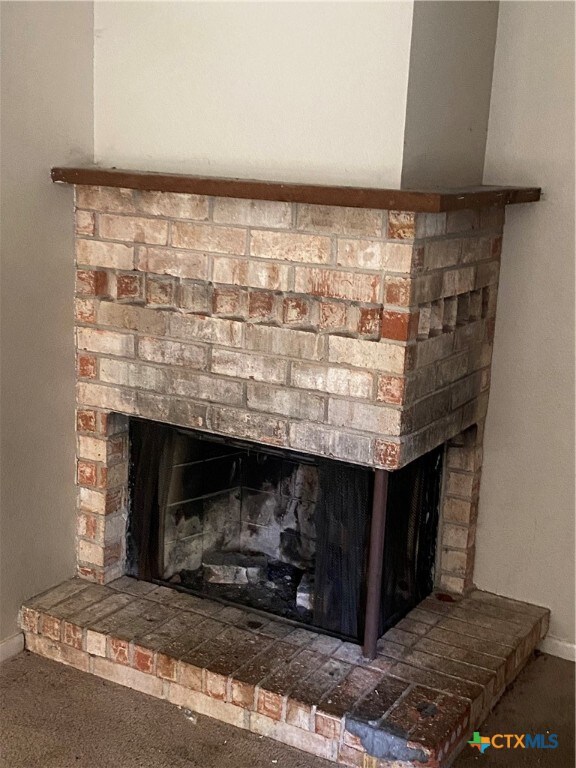 interior details with a brick fireplace and carpet