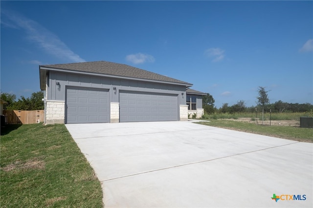 exterior space featuring driveway, an attached garage, board and batten siding, and a yard