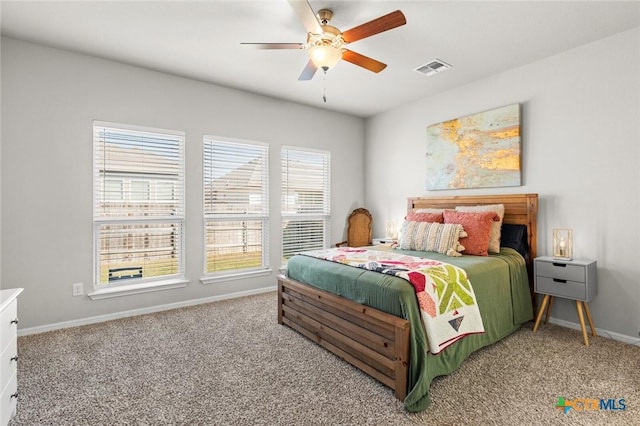 carpeted bedroom with visible vents, baseboards, and a ceiling fan