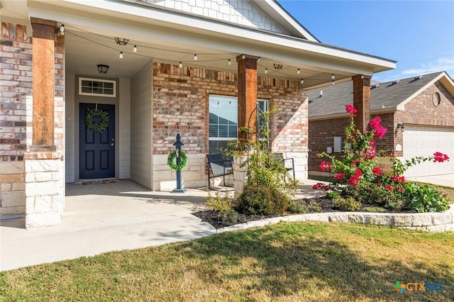 view of exterior entry with brick siding, covered porch, and an attached garage