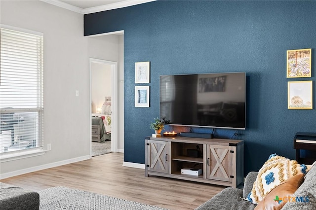 living area with baseboards, wood finished floors, and crown molding