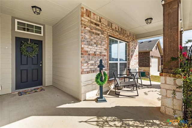 property entrance with a porch and brick siding