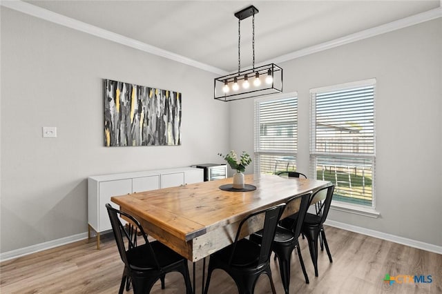 dining room featuring an inviting chandelier, light wood-type flooring, baseboards, and ornamental molding