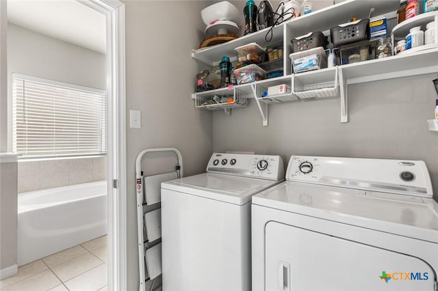 laundry area with laundry area, light tile patterned flooring, and washer and clothes dryer