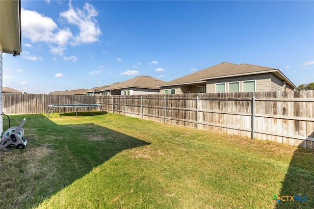 view of yard featuring a fenced backyard and a trampoline