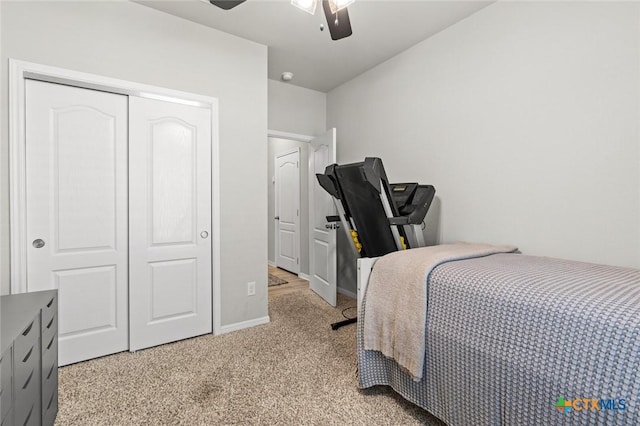 bedroom featuring baseboards, a ceiling fan, a closet, and light carpet