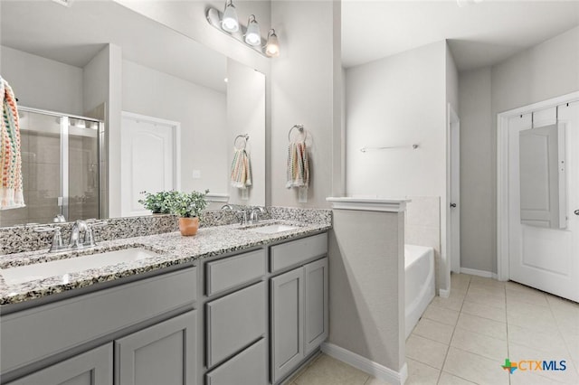 bathroom with tile patterned floors, a stall shower, double vanity, and a sink