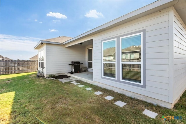 back of property with a patio area, a yard, and fence