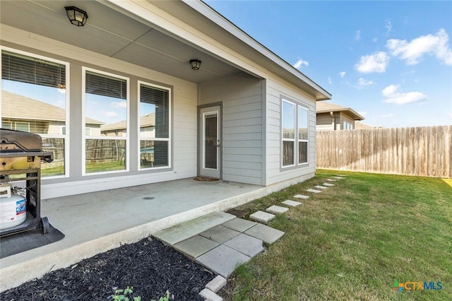 exterior space featuring a patio area, a yard, and fence