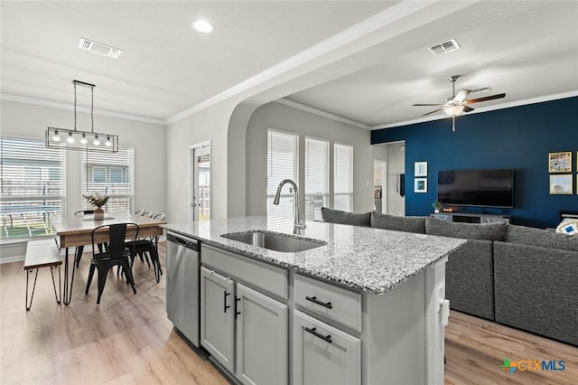 kitchen with stainless steel dishwasher, light wood-style flooring, visible vents, and a sink