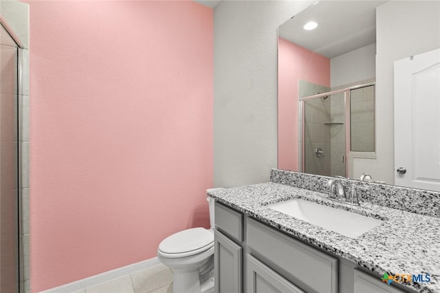 full bath with tile patterned floors, toilet, a tile shower, baseboards, and vanity