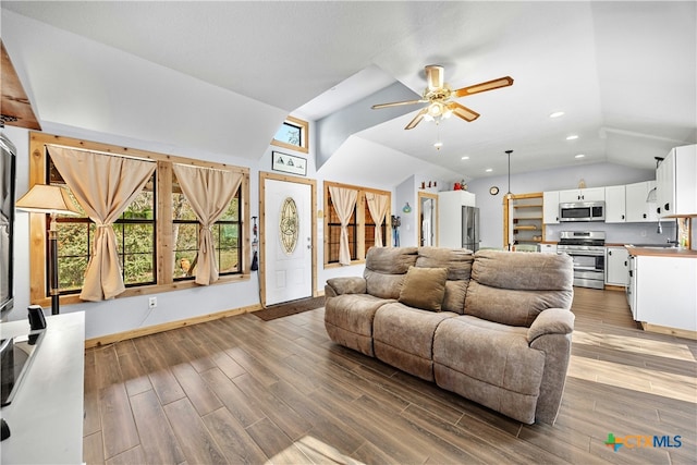 living room featuring ceiling fan, vaulted ceiling, and hardwood / wood-style flooring