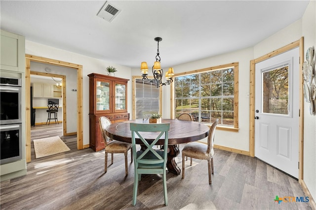 dining area with hardwood / wood-style flooring and a notable chandelier