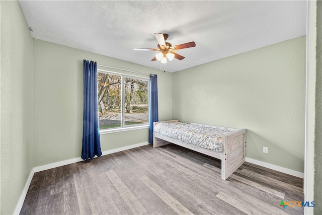 unfurnished bedroom featuring wood-type flooring and ceiling fan