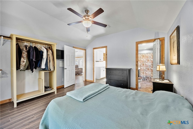 bedroom featuring ceiling fan, dark wood-type flooring, connected bathroom, a closet, and lofted ceiling