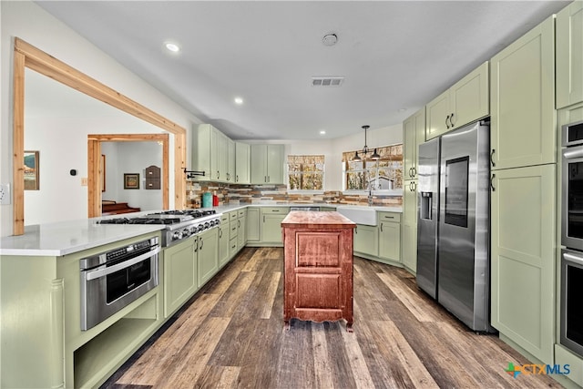 kitchen with kitchen peninsula, stainless steel appliances, dark hardwood / wood-style floors, and green cabinets