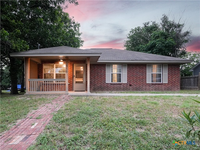 ranch-style house featuring a lawn and a porch