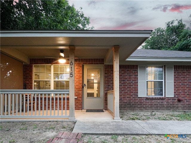 exterior entry at dusk featuring covered porch