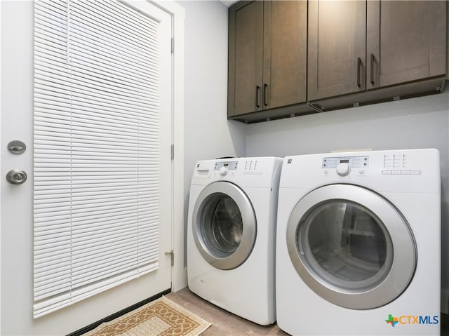 laundry room featuring cabinets, independent washer and dryer, and light wood-type flooring