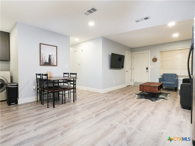 living room featuring light wood-type flooring and washer / clothes dryer