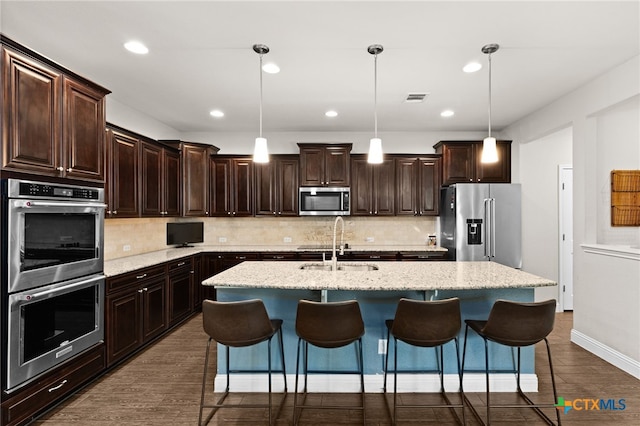 3256 Province Pt, Harker Heights, TX 76548 - kitchen with appliances with stainless steel finishes, an island with sink, dark brown cabinets, backsplash, and recessed lighting