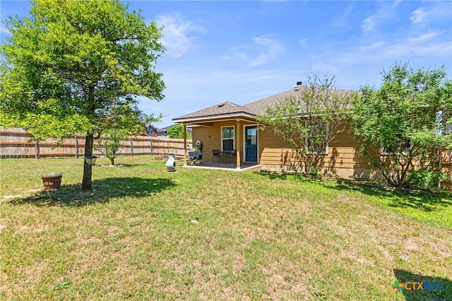 rear view of house featuring a patio area, a fenced backyard, and a yard