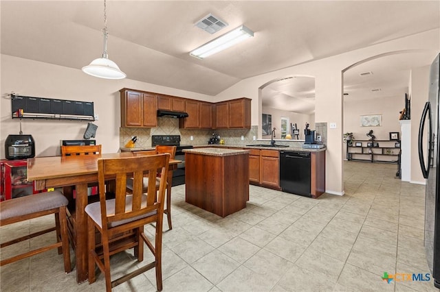 kitchen with vaulted ceiling, a sink, black appliances, backsplash, and under cabinet range hood