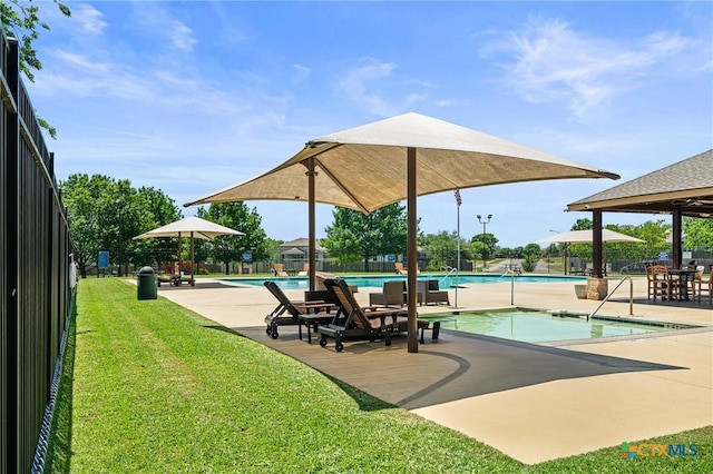 view of property's community with fence, a lawn, a pool, and a patio area