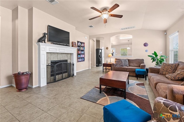 living room with ceiling fan, arched walkways, light tile patterned flooring, and visible vents