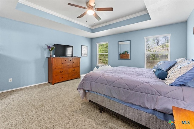 bedroom featuring multiple windows, crown molding, carpet flooring, and a tray ceiling