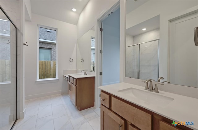 264 Five Mile Creek Way, Kyle, TX 78640 - full bath featuring a stall shower, two vanities, marble look tile flooring, baseboards, and plenty of natural light