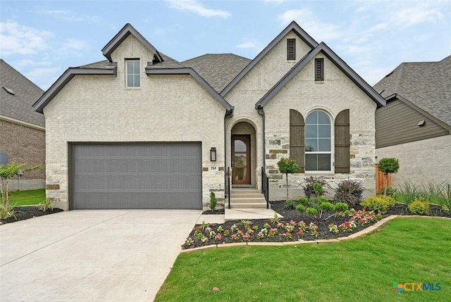 264 Five Mile Creek Way, Kyle, TX 78640 - french country inspired facade featuring a front yard, concrete driveway, stone siding, a garage, and a shingled roof