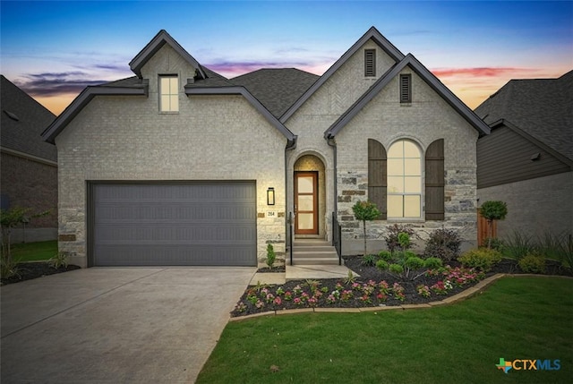 264 Five Mile Creek Way, Kyle, TX 78640 - french country inspired facade with driveway, stone siding, a front lawn, and a garage
