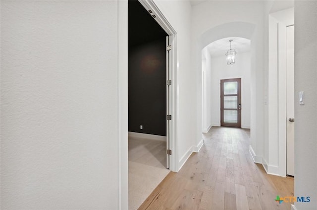 264 Five Mile Creek Way, Kyle, TX 78640 - hallway with arched walkways, light wood-style floors, and baseboards