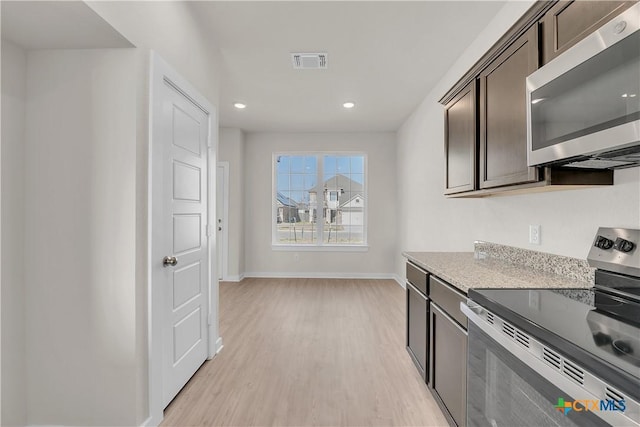 kitchen featuring stainless steel appliances, dark brown cabinetry, and light hardwood / wood-style flooring