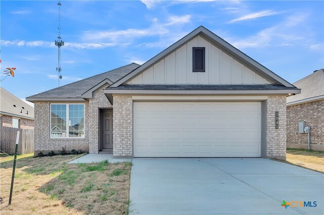 view of front of home with a garage, a front yard, and central AC unit