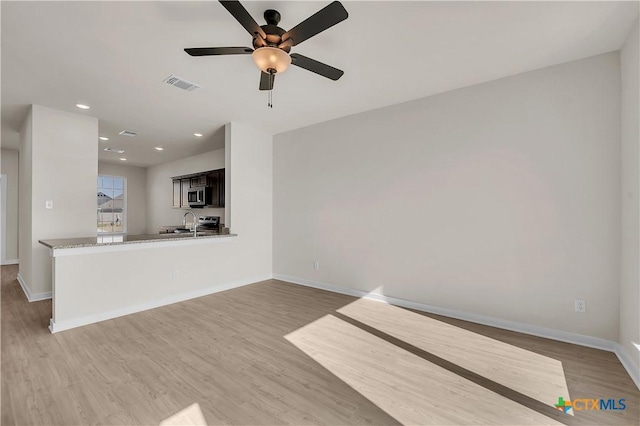 unfurnished living room featuring light hardwood / wood-style flooring and ceiling fan