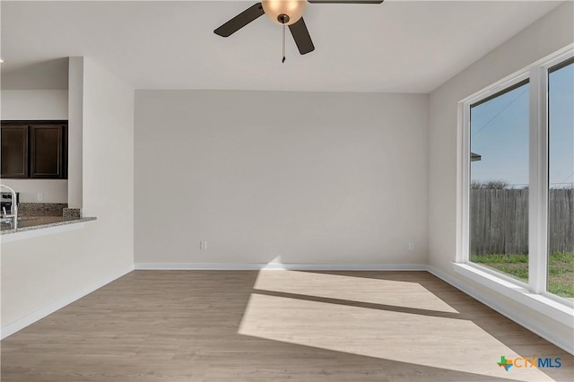 unfurnished room featuring ceiling fan, sink, and light hardwood / wood-style floors