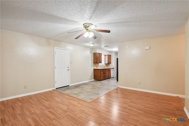 unfurnished living room with a textured ceiling, light hardwood / wood-style flooring, and ceiling fan