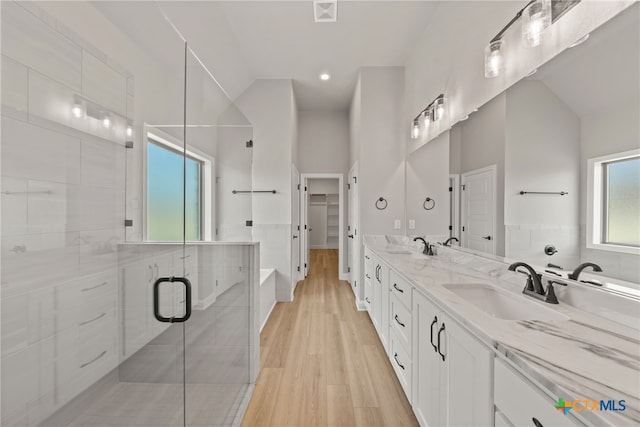 bathroom with hardwood / wood-style floors, vanity, an enclosed shower, and vaulted ceiling