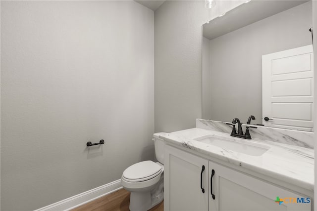 bathroom featuring hardwood / wood-style flooring, vanity, and toilet