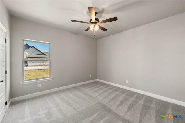 carpeted spare room featuring ceiling fan