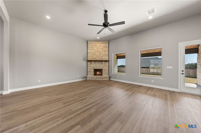 unfurnished living room featuring ceiling fan, a fireplace, and light hardwood / wood-style floors