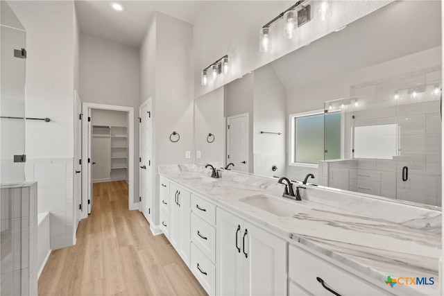 bathroom with a shower with door, vanity, and hardwood / wood-style flooring