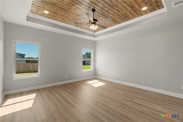 spare room with a tray ceiling, light hardwood / wood-style flooring, and wooden ceiling