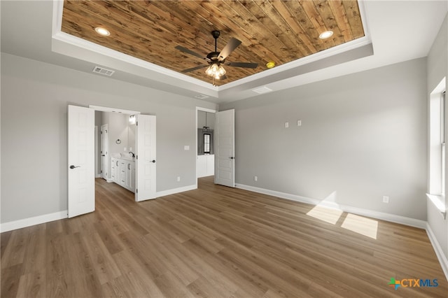 unfurnished bedroom with hardwood / wood-style flooring, wood ceiling, ornamental molding, and a tray ceiling