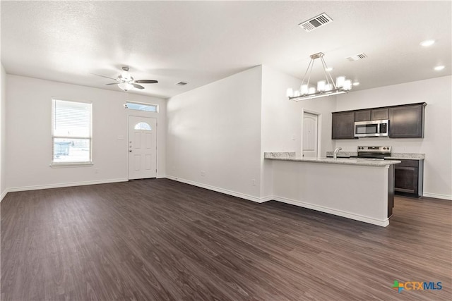 entryway with visible vents, baseboards, dark wood-style flooring, and ceiling fan with notable chandelier