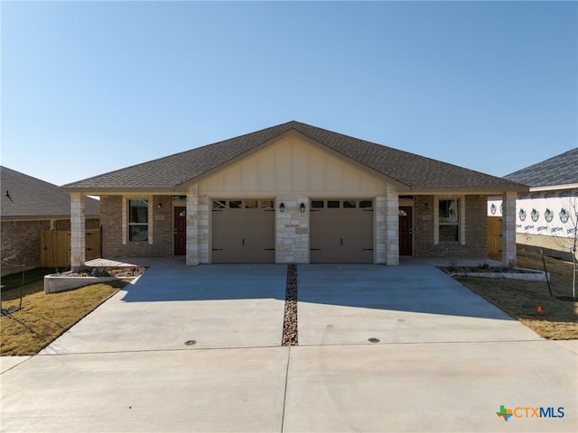 ranch-style house with board and batten siding, fence, brick siding, and a garage