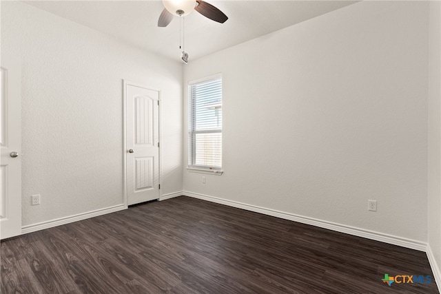 empty room with baseboards, ceiling fan, and dark wood-style flooring