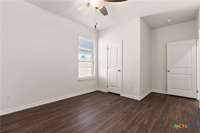 unfurnished bedroom with dark wood finished floors, a ceiling fan, and baseboards